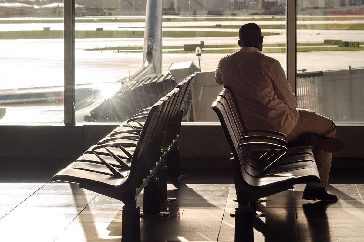 Voyageur patientant devant les pistes d'un aéroport
