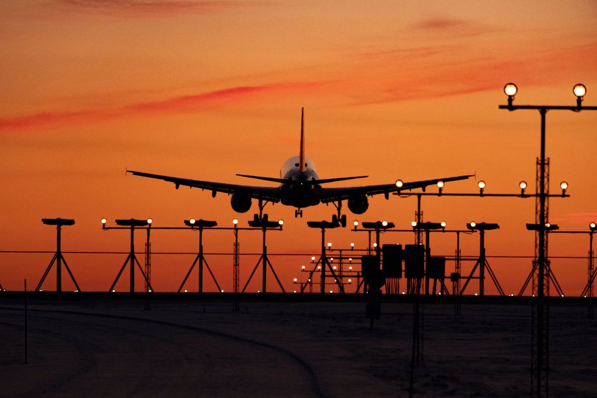Avion à l'atterrissage au coucher du soleil