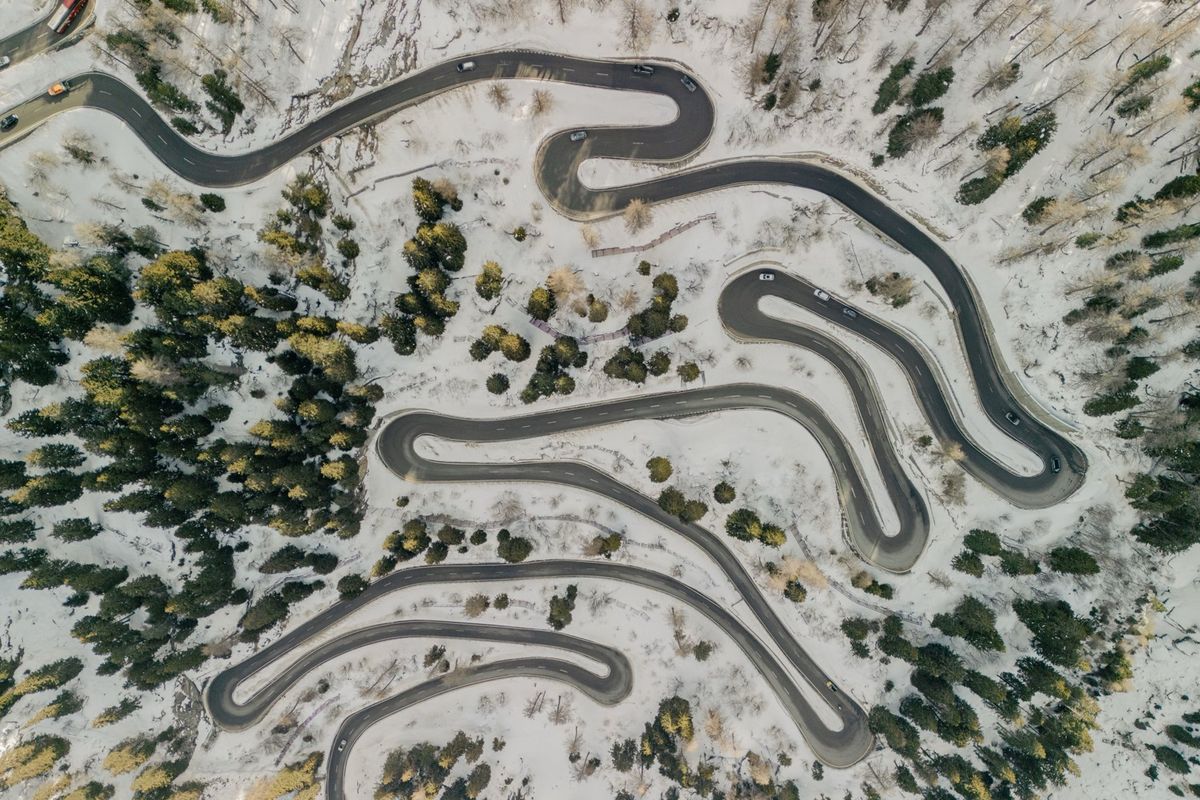 Lacets d'une route de montagne enneigée, vue du ciel