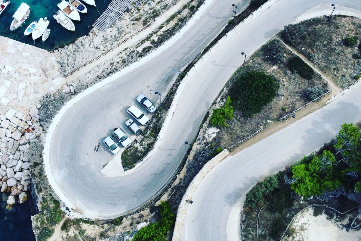Route en lacets au-dessus d'un petit port, vue du ciel