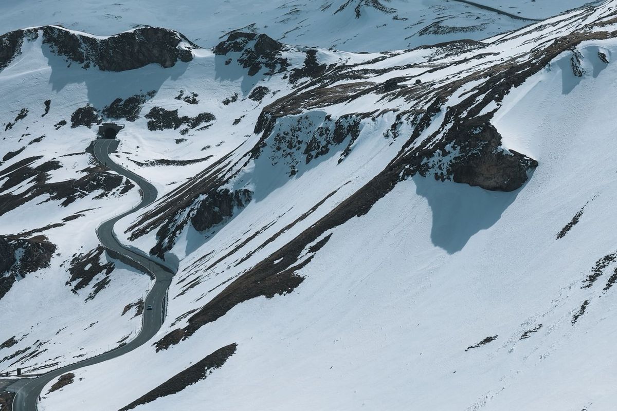 Route sinueuse dans un paysage alpin enneigé